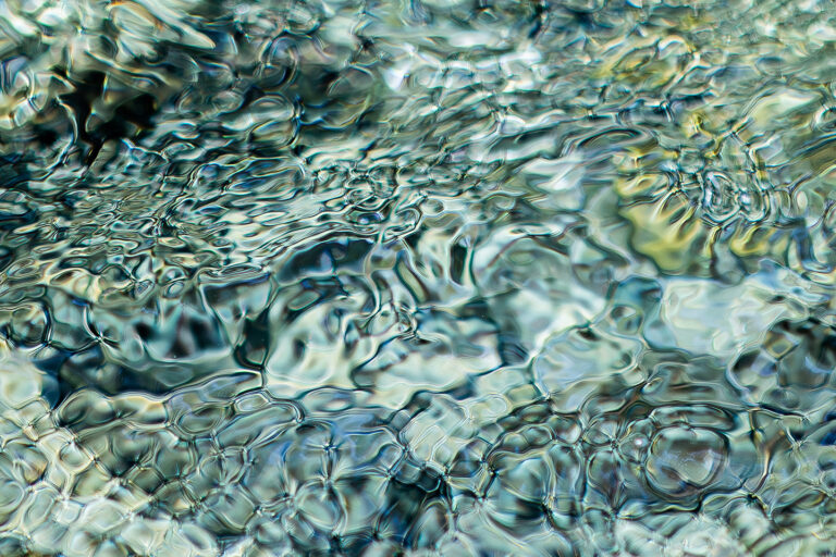 Fine art macro photography of water surface texture, abstract green and gold ripple patterns